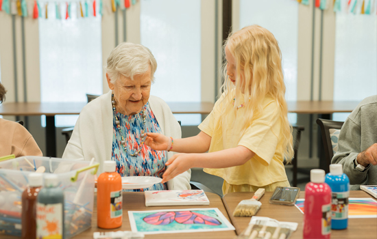 Resident crafts with granddaughter at The Gardens of Sun City Memory Care Community in Sun City, AZ