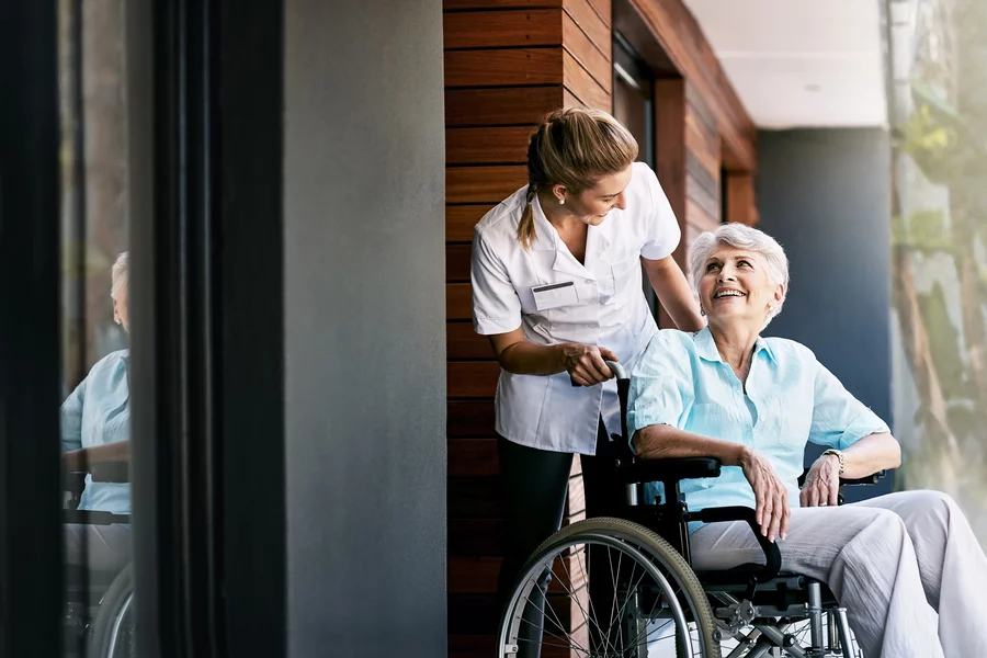 Nurse, talking and senior woman on wheelchair for support