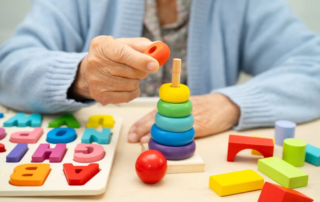 Elderly woman stacks colored rings to help rehabilitate stages of dementia symptoms.