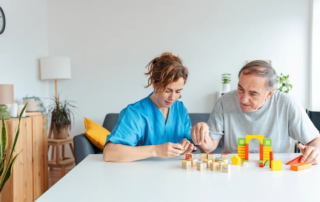 Professional nurse caregiver in geriatric clinic helps senior man with Alzheimer's disease